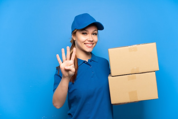 Repartidora sobre pared azul aislada feliz y contando cuatro con los dedos