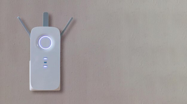 Repetidor inalámbrico Wifi Extender en fondo de pared gris vacío Refuerzo de red espacio de copia de cerca