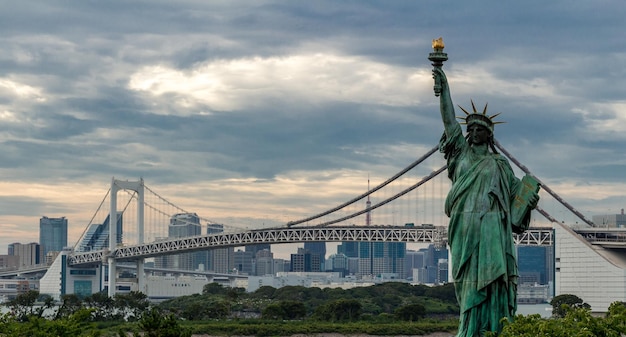 Réplica da Estátua da Liberdade e da Ponte do Arco-íris contra o céu nublado