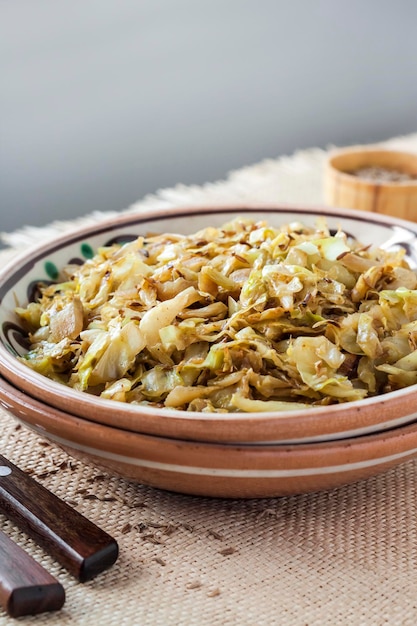 Repollo blanco frito con semillas de alcaravea y curry en polvo en placa rústica