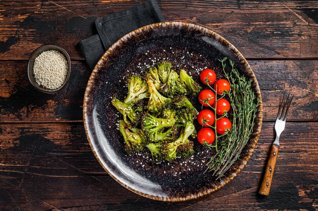 Repollo brócoli asado a la plancha con hierbas en un plato. Fondo de madera. Vista superior.