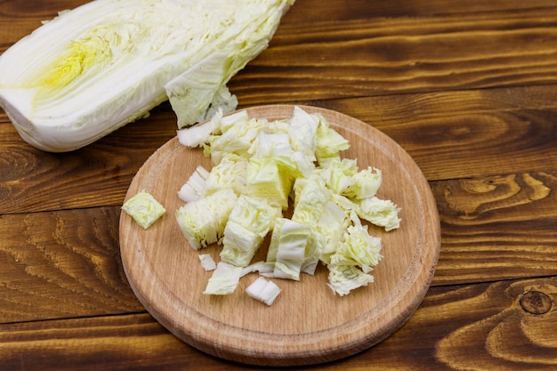 Repollo chino picado en tabla de cortar en mesa de madera