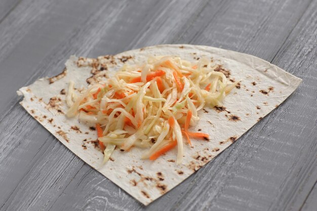 Repollo en escabeche y pan de pita sobre la mesa de madera