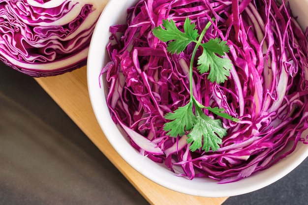 Foto repollo morado fresco rebanado para rallar y decorar con cilantro en la mesa de granito.