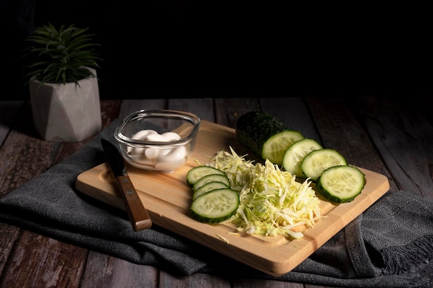 El repollo y el pepino en rodajas yacen sobre la mesa en la cocina