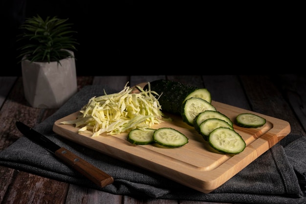 Foto el repollo y el pepino en rodajas yacen sobre la mesa en la cocina