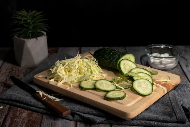 El repollo y el pepino en rodajas yacen sobre la mesa en la cocina