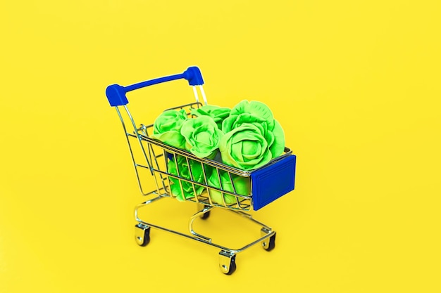 Repollo de plastilina en un carrito de compras sobre un fondo amarillo Alimentos saludables antioxidantes cuidado de la salud