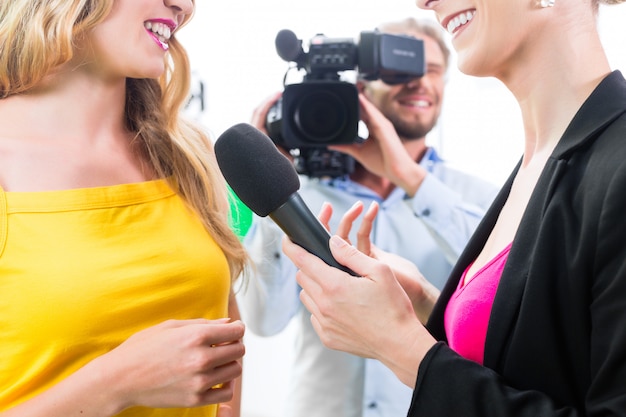 Foto repórter e cinegrafista filmam uma entrevista