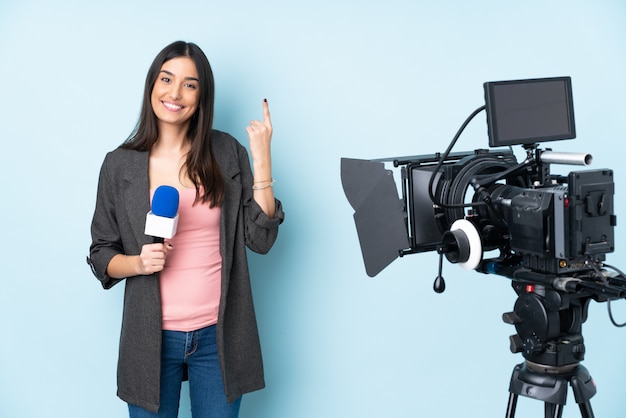 Repórter mulher segurando um microfone e reportar notícias em azul apontando para cima uma ótima idéia