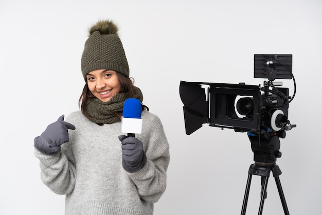 Reporterfrau, die ein Mikrofon hält und Nachrichten über lokalisierter weißer Wand stolz und selbstzufrieden berichtet