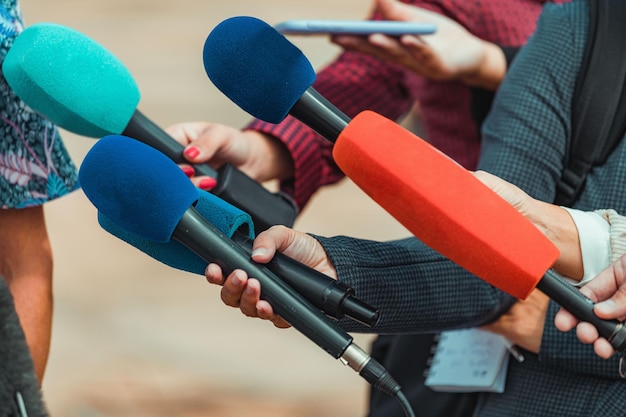 Foto reporteros de noticias entrevistando a una gente irreconocible al aire libre