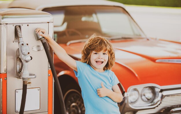 Repostar el coche Gasolinera Kid contra automóvil retro rojo