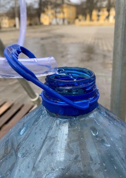 Se representa una botella de plástico en la que se extrae agua de un grifo.