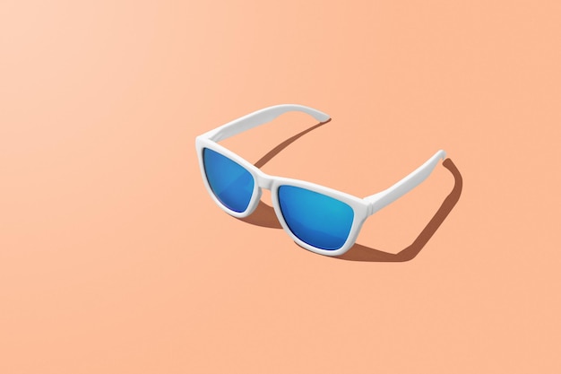 Representación 3D de gafas de sol azules sobre fondo de color Peach Fuzz del año y espacio de copia