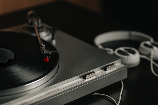 reproductor de vinilo en una mesa con auriculares blancos