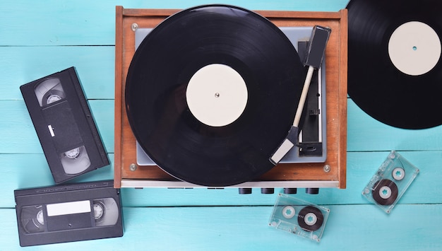 Reproductor de vinilo vintage con placas, videocasete y audiocasete