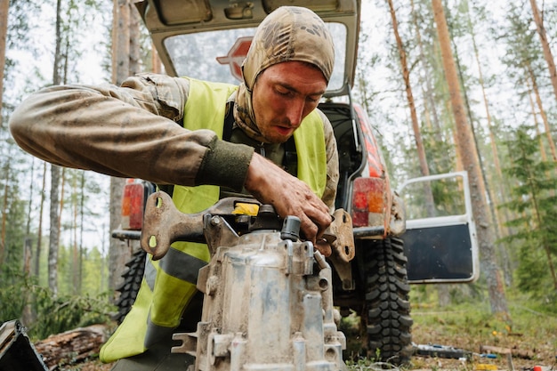 República da carélia rússia circa junho de 2022 torneio offroad ladoga trophy 2022 ao redor do lago ladoga um piloto repara a transmissão de um jipe suv