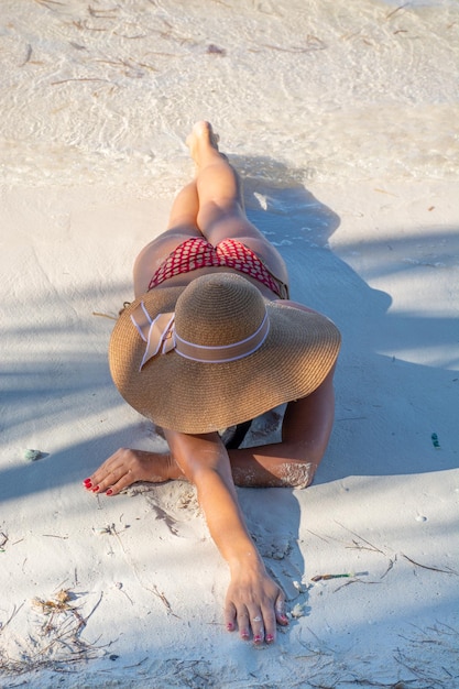 República Dominicana de Punta Cana una chica con sombrero en el océano con agua turquesa y palmeras