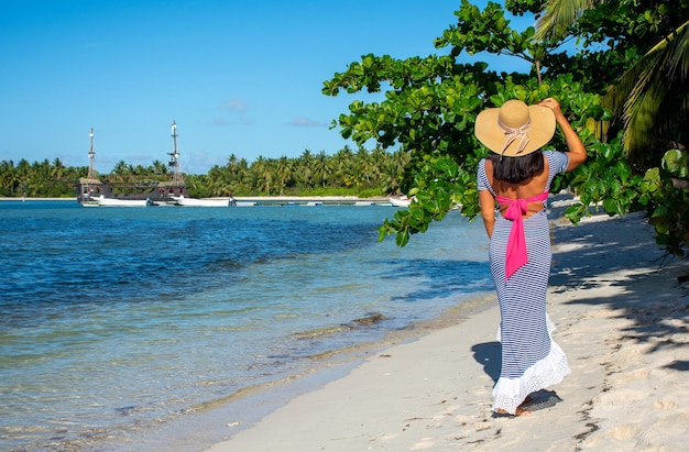 República Dominicana de Punta Cana una chica con sombrero en el océano con agua turquesa y palmeras