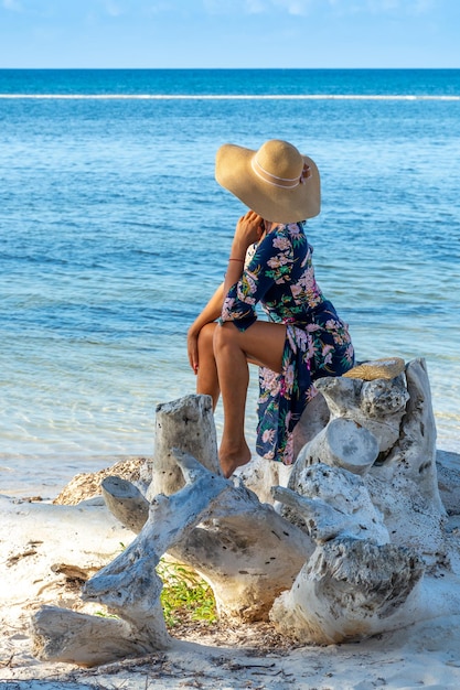 República Dominicana de Punta Cana una chica con sombrero en el océano con agua turquesa y palmeras