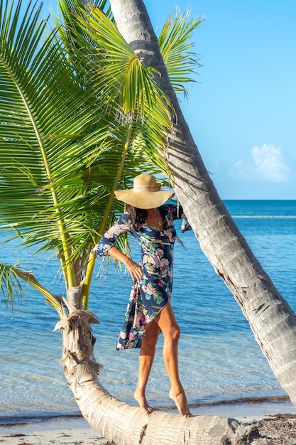 República Dominicana de Punta Cana una chica con sombrero en el océano con agua turquesa y palmeras