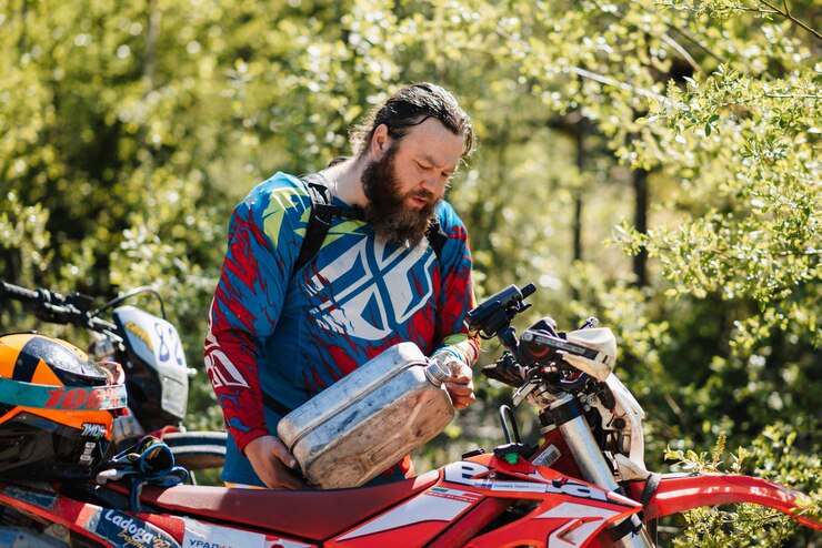Foto república de karelia rusia alrededor de junio de 2022 torneo offroad ladoga trophy 2022 en karelia un corredor de motocicletas llena gasolina de un bote en el tanque