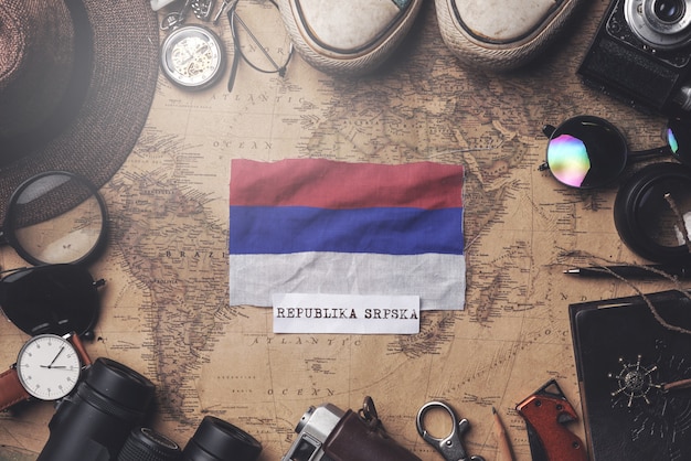 Republika Srpska Flagge zwischen dem Zubehör des Reisenden auf alter Weinlese-Karte. Obenliegender Schuss