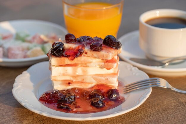 Requeijão com suco de laranja com geléia de cereja vermelha e xícara de café na mesa Conceito de café da manhã