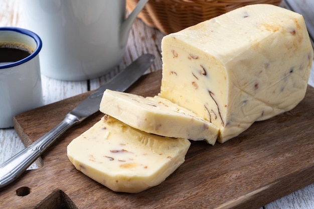 Foto requeijao de corte queso crema tradicional brasileño con café y pan sobre una mesa de madera