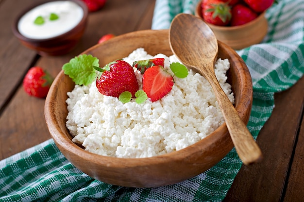 Requesón con fresas en un tazón de madera