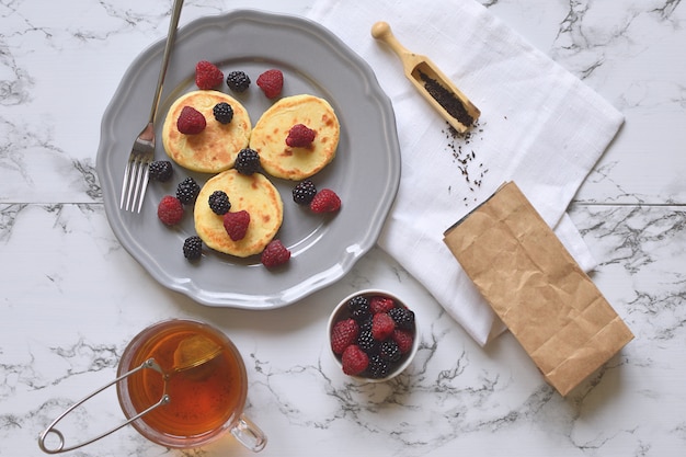 Requesón Panqueques Desayuno saludable Frambuesa sin zarzamora sin gluten Hoja de té Taza de mármol Vista superior Endecha plana