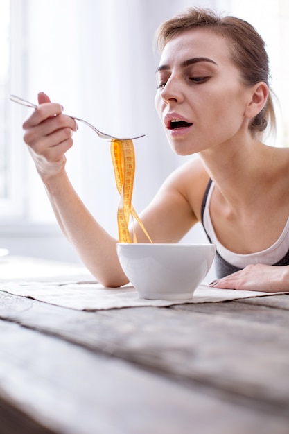 Requisitos profesionales. Infelices mujeres jóvenes mirando su comida mientras mantienen una dieta