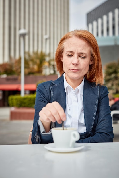 Reservando um momento para recarregar as baterias, uma empresária de meia-idade bem-sucedida desfruta de uma pausa para o café tranquila