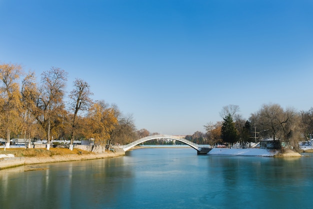 Reservatório no Parque Nacional do Uzbequistão no inverno e uma ponte sobre o lago em um dia ensolarado