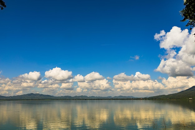 Un reservorio natural en el valle durante el día, cielo azul brillante con nubes.