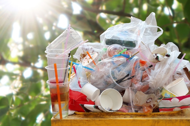 Residuos de bolsas de plástico Gran cantidad de basura en el desenfoque de fondo de sol de árbol