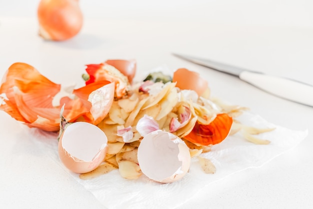 Residuos orgánicos de comida casera listos para compostar. Concepto ecológico. Restos de comida, peladuras de verduras en la mesa de la cocina. Comportamiento ambientalmente responsable, manejo de residuos, reciclaje de basura.