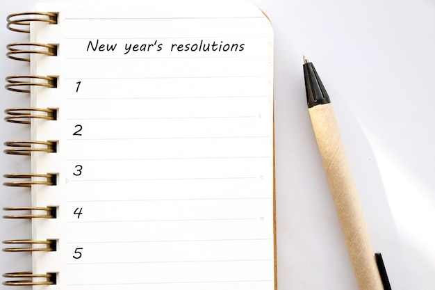 Resoluções de 2019 no caderno em branco sobre fundo de mármore branco