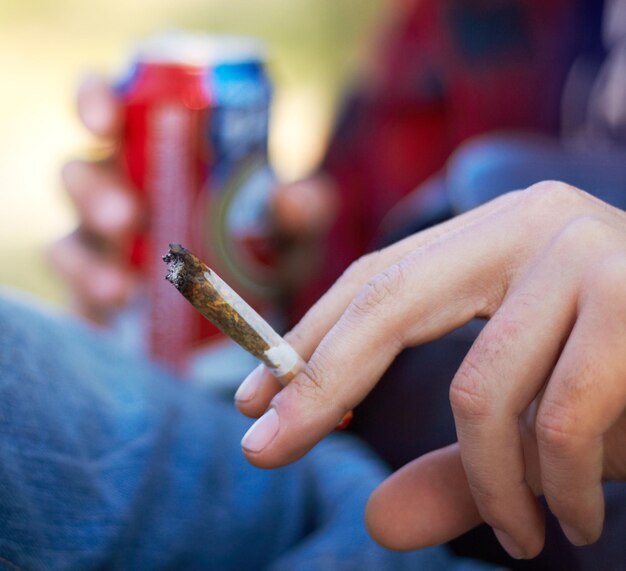 Foto resoplando todo el día toma de una persona irreconocible fumando un gran porro de marihuana