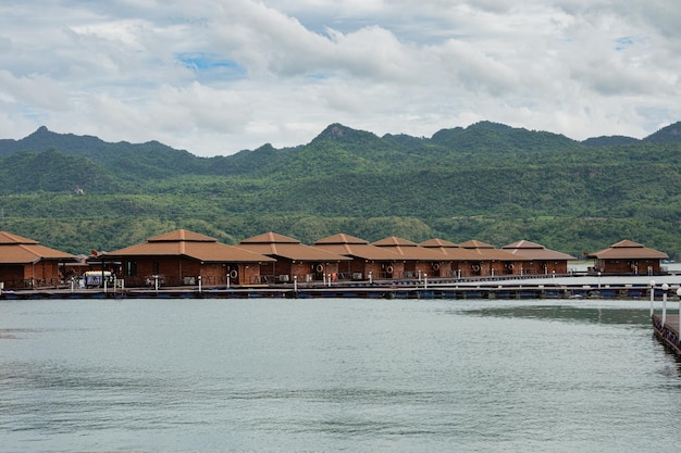 Foto resort de jangada de madeira flutuando com montanha na barragem