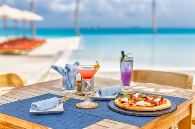 Resort de luxo à beira da piscina, restaurante ao ar livre na praia, oceano e céu, café da ilha tropical