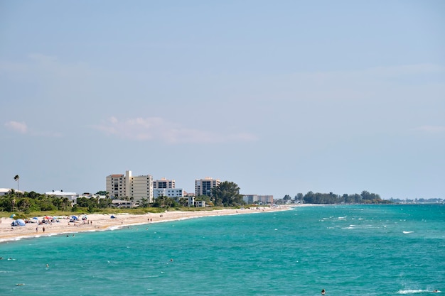 Resort playa con arena blanca agua azul altos edificios de hotel Gente feliz tomando el sol y nadando en el océano