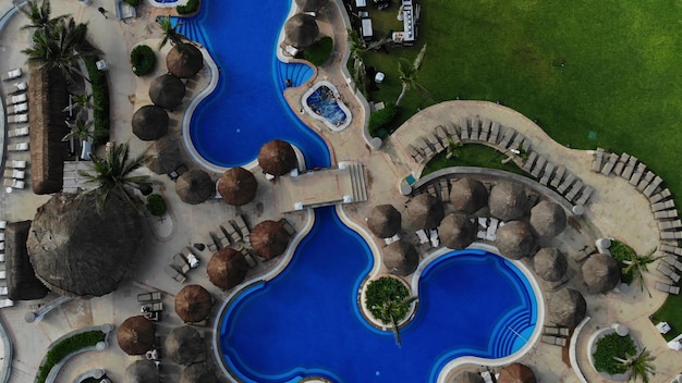 Resort de vacaciones en cancún méxico en vista aérea con piscina de hotel con camas de sombrillas