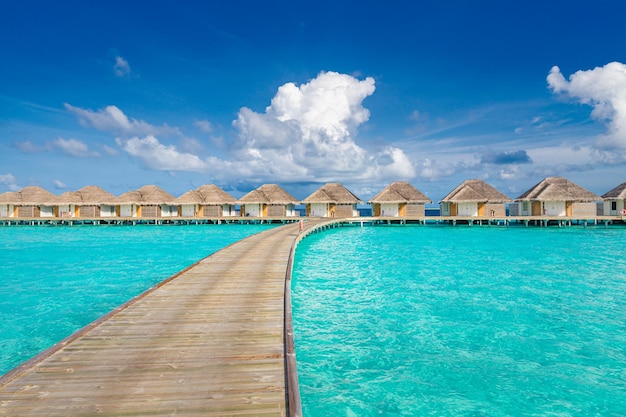 Resort de villas de agua de lujo y muelle de madera Hermoso cielo y nubes y verano de fondo de playa