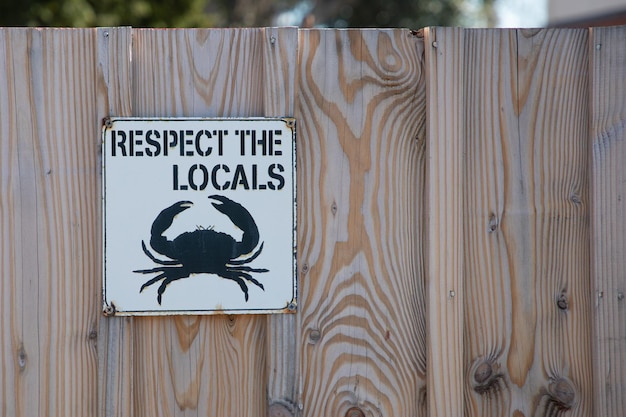 Respeite o texto local na cerca de madeira com desenho de caranguejo ícone