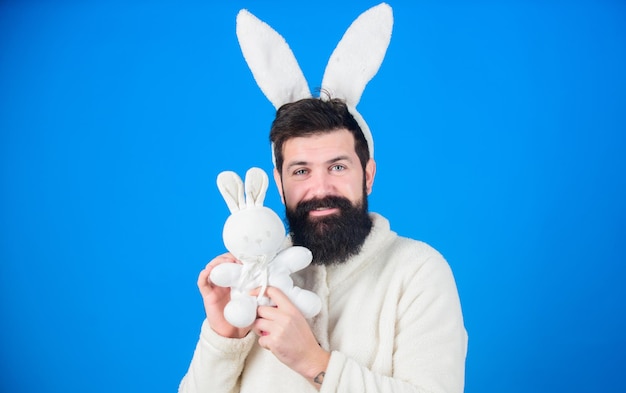 Respekt für Traditionen Osterhase Mann mit Hasenplüschanzug Lustiger Hasenmann mit Bart und Schnurrbart Ostersymbolkonzept Guy bärtiger Hipster süßer sanfter Hase mit langen Ohren blauer Hintergrund