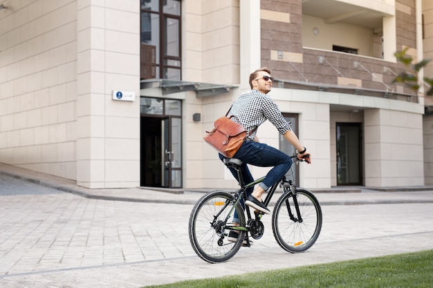 Respetuoso del medio ambiente. Hombre positivo feliz en bicicleta mientras va a trabajar