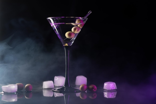 Respingo de bebida de coquetel Martini com cubos de gelo em cores neon iridescentes rosa e azul Conceito mínimo de vida de festa noturna
