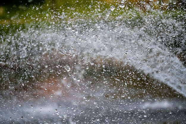 Respingos de água com pequenas gotas no foco seletivo do fundo natural abstrato da fonte